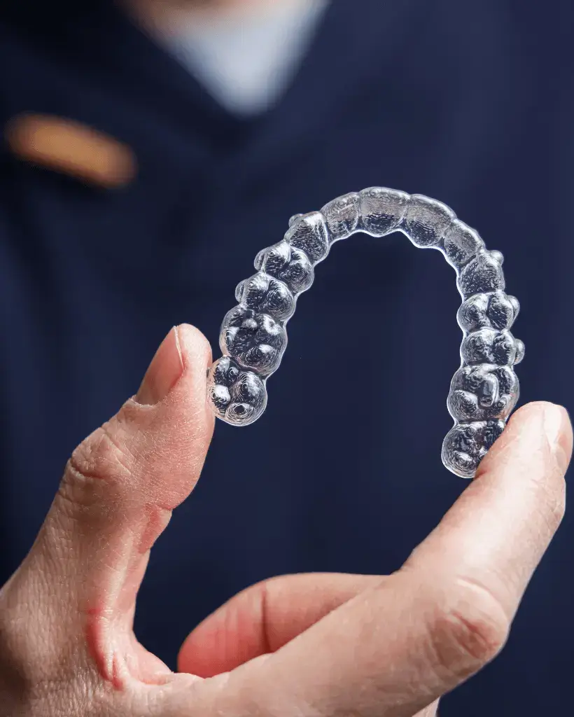 Orthodontist holding clear aligners